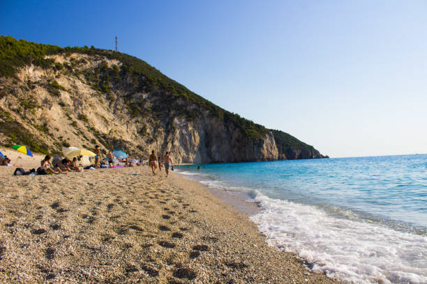 lefkada, Greece,8/20/2018 people having a good time at the beach swimming playing sunbathing lefkada, Greece,8/20/2018 people having a good time at the beach swimming playing sunbathing egremni beach lefkada island greece stock pictures, royalty-free photos & images
