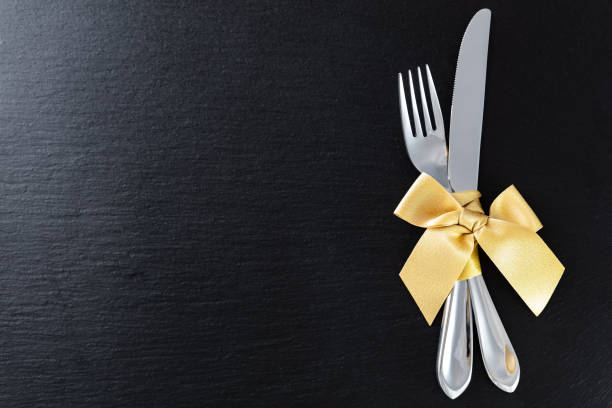 istock fork and knife with golden ribbon on slate tray 1097907846