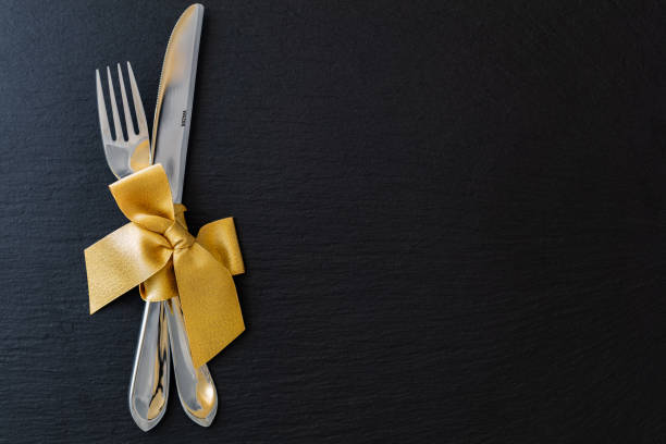 istock fork and knife with golden ribbon on slate tray 1097907848
