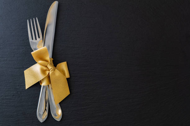 istock fork and knife with golden ribbon on slate tray 1097907916