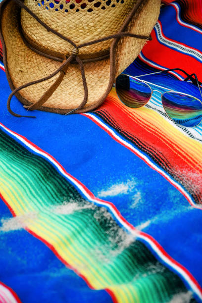 istock Sunglasses, straw hat and Mexican blanket at the beach 1097909088