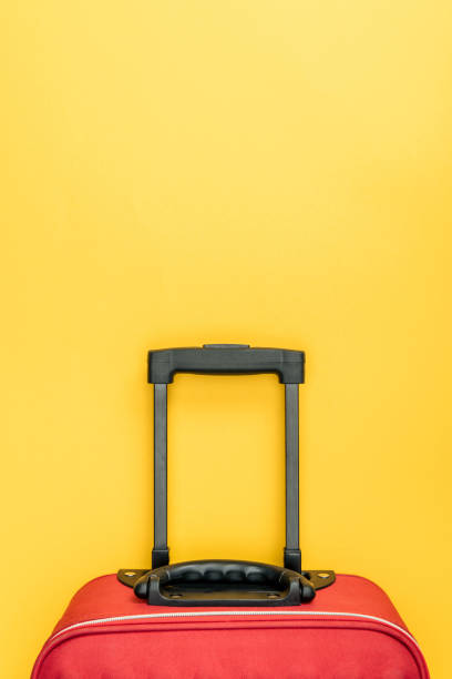 istock top view of red baggage with handle on yellow background 1097910696