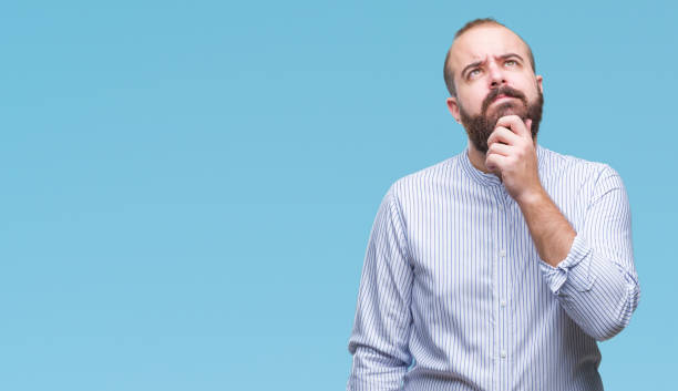istock Young caucasian hipster man over isolated background with hand on chin thinking about question, pensive expression. Smiling with thoughtful face. Doubt concept. 1097918032