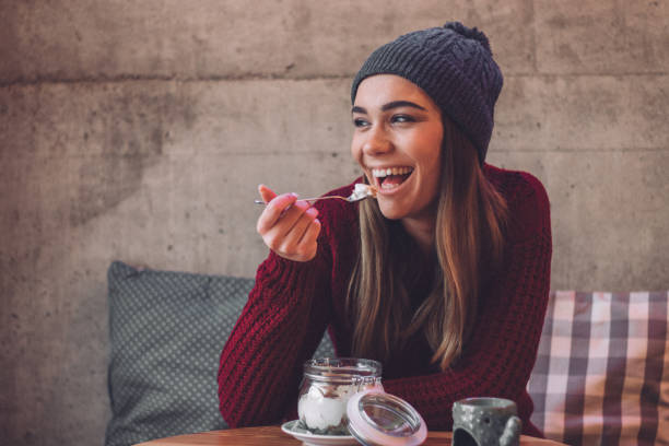 donna felice che mangia sano spuntino dolce - nut snack fruit healthy eating foto e immagini stock