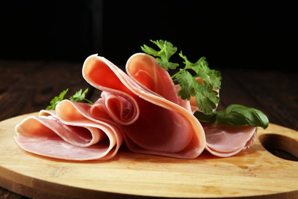 istock Sliced ham with parsley on table. Fresh prosciutto. Pork ham sliced. 1097918322