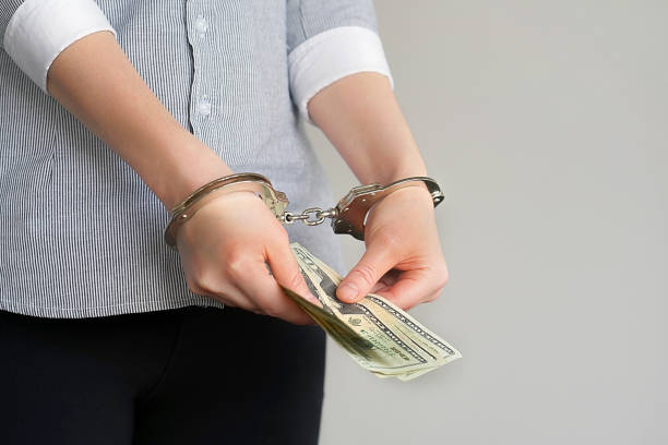istock Business women in handcuffs with a bribe 1097930272