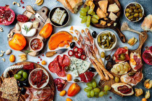 cheese and meat platter over grey concrete background. Top view Appetizers table with antipasti snacks. Brushetta or authentic traditional spanish tapas set, cheese and meat platter over grey concrete background. Top view pomegranate in spanish stock pictures, royalty-free photos & images