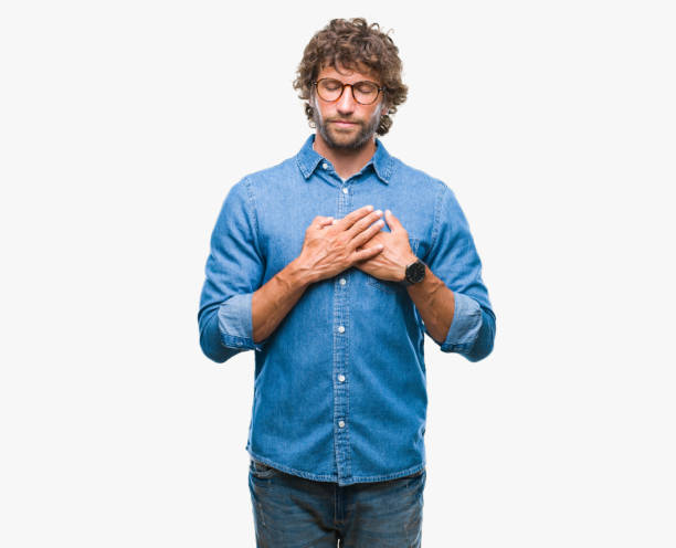 istock Handsome hispanic model man wearing glasses over isolated background smiling with hands on chest with closed eyes and grateful gesture on face. Health concept. 1097938200
