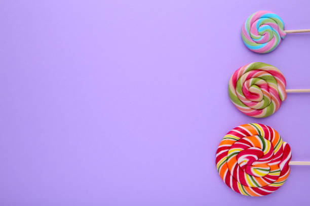 istock Many colorful lollipops on purple background, Sweets 1097941492