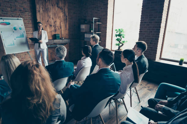 istock Nice beautiful elegant classy clever smart speaker presenter trainee speaking to business people sitting on chairs finance economy company financial strategy at work place station open space 1097945036