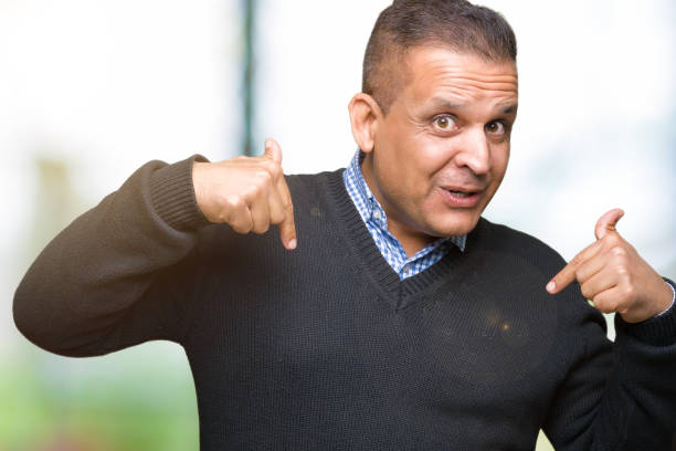 istock Handsome middle age man over isolated background looking confident with smile on face, pointing oneself with fingers proud and happy. 1097947452