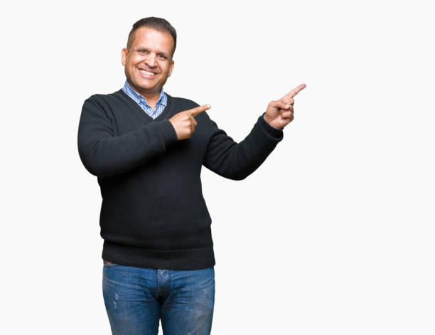 istock Handsome middle age man over isolated background smiling and looking at the camera pointing with two hands and fingers to the side. 1097951142