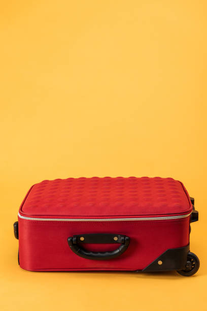 travel bag with wheels on yellow background