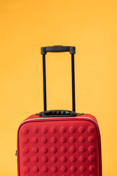 istock red travel bag with handle isolated on yellow 1097952382