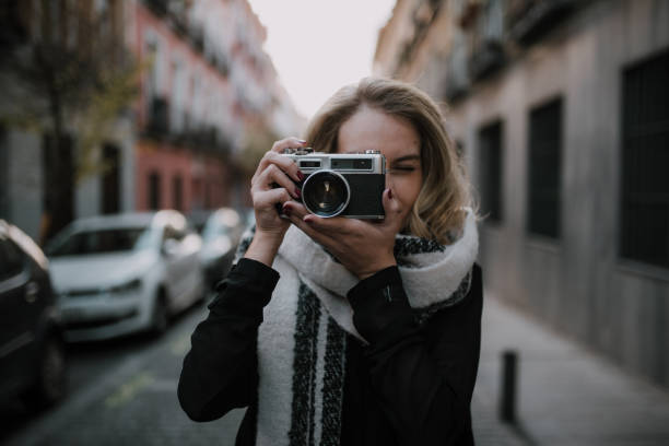 istock Young woman using a vintage camera 1097954858