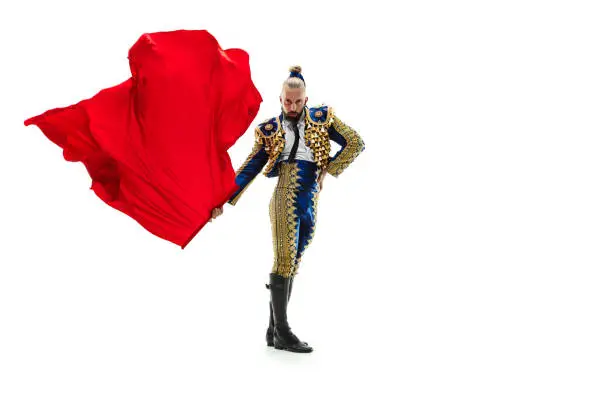 Torero in blue and gold suit or typical spanish bullfighter isolated over white studio background. The taming, achieving the goal, mortification, conquest, boss, leadership, battle, win, winner concept