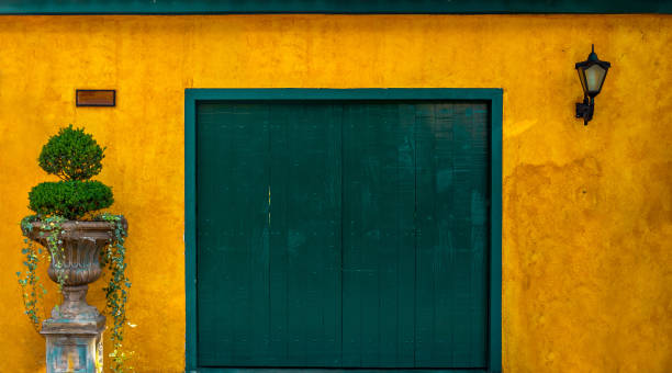 Embu das Artes, São Paulo/Brazil - 26 DECEMBER, 2018 Green wooden door on a yellow textured colonial wall historic center of Embu das Artes Sao Paulo rustic door stock pictures, royalty-free photos & images