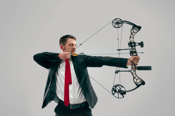 istock Businessman aiming at target with bow and arrow, isolated on white background 1097963392