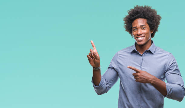 istock Afro american man over isolated background smiling and looking at the camera pointing with two hands and fingers to the side. 1097963858
