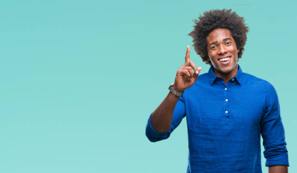 istock Afro american man over isolated background pointing finger up with successful idea. Exited and happy. Number one. 1097964120