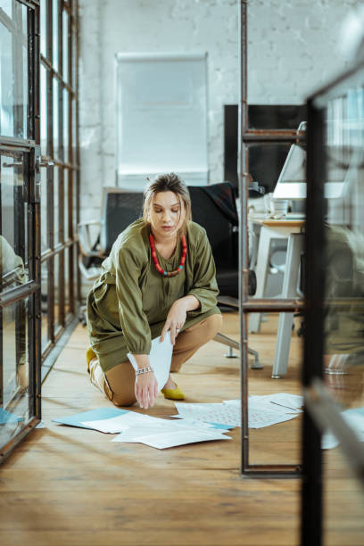 istock Pregnant woman after dropping documents on the floor 1097964274
