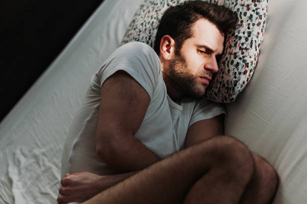 istock Young depressed man in pain on the bed 1097966912
