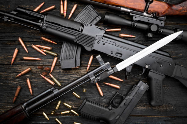 istock Guns and ammo laying on a wooden floor 1097967408