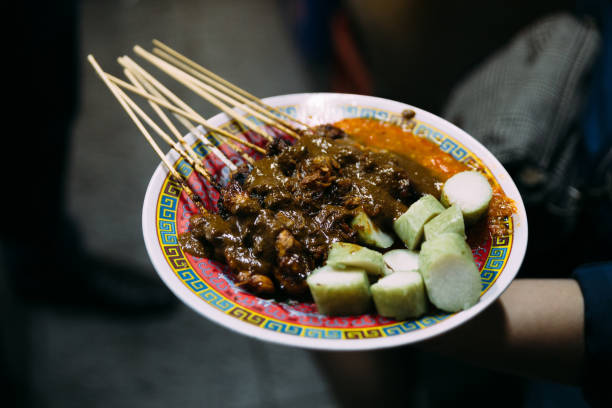istock Roasting meat, chicken and mutton satays grilled by charcoal, served with sticky rice at night market in Jakarta, Indonesia. 1097968084