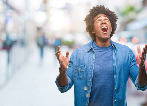 istock Afro american man over isolated background crazy and mad shouting and yelling with aggressive expression and arms raised. Frustration concept. 1097970156