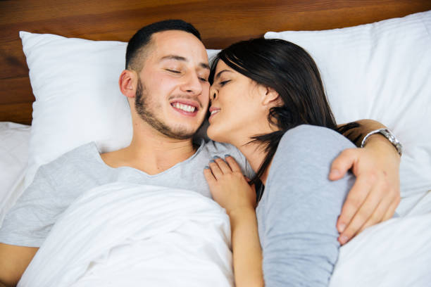 istock Young couple in bed embracing. 1097982022
