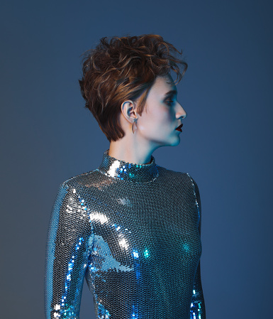Woman with short haircut and wearing futuristic sequin top
