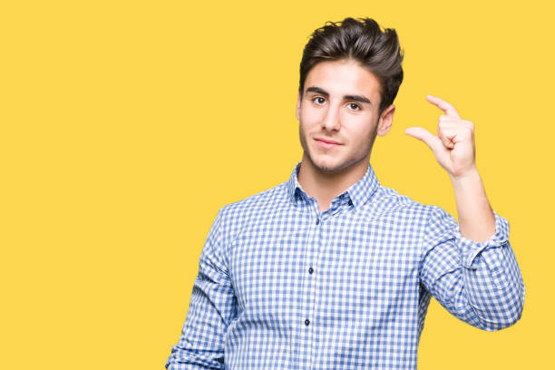 istock Young handsome business man over isolated background smiling and confident gesturing with hand doing size sign with fingers while looking and the camera. Measure concept. 1097995230
