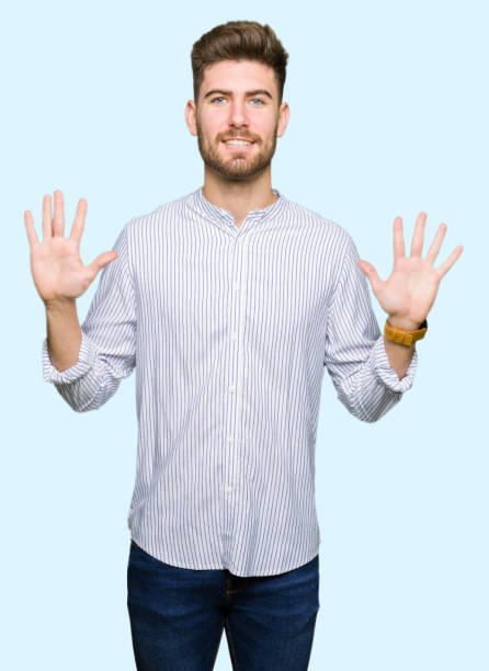 istock Young handsome man showing and pointing up with fingers number ten while smiling confident and happy. 1097998536