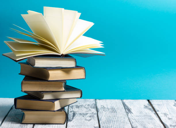istock Open book, hardback books on wooden table. Back to school. Copy space 1097999238