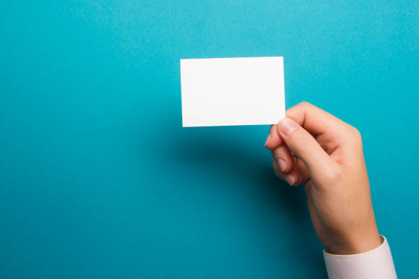 Hand holding white business card on white background