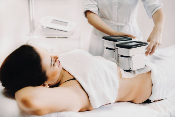 Adult woman doing cryolipolysis fat treatment procedure in a sal stock photo