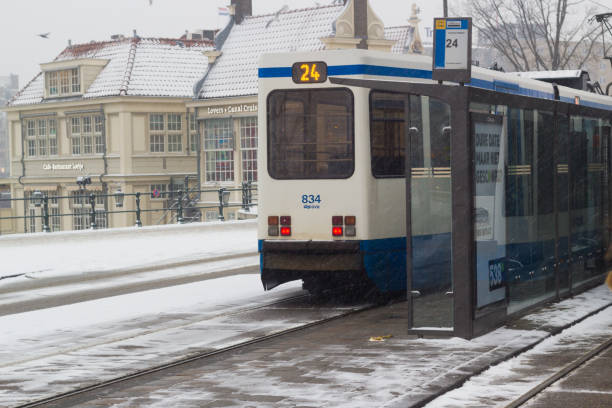 fast tram at Amsterdam central in the snow Amsterdam, the Netherlands - January 22 2019: GVB fast tram at Amsterdam central in snow view from above tasrail stock pictures, royalty-free photos & images