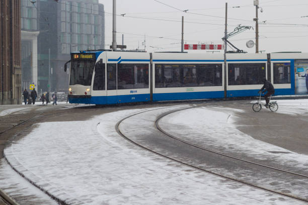 fast tram at Amsterdam central in the snow Amsterdam, the Netherlands - January 22 2019: GVB fast tram at Amsterdam central in snow view from above tasrail stock pictures, royalty-free photos & images