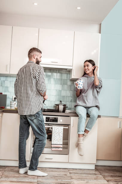 istock Caring husband standing near cooker while frying some meat 1098009822