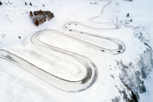 Aerial view of mountain, winding road with cars in winter Julier Pass, Swiss Alps.