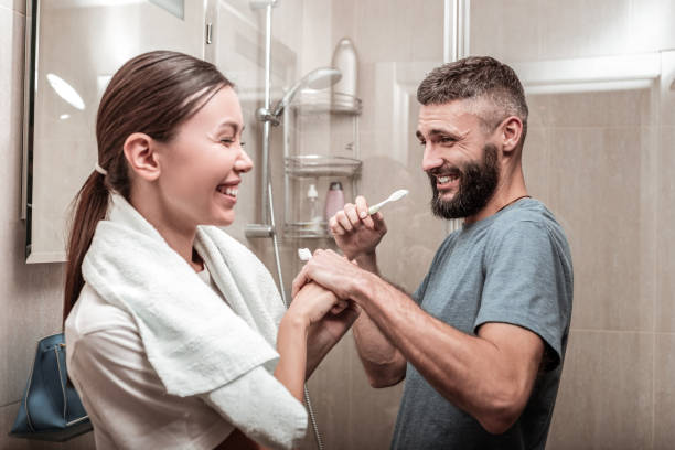 istock Dark-haired woman using cream for sensitive skin looking into mirror 1098010114