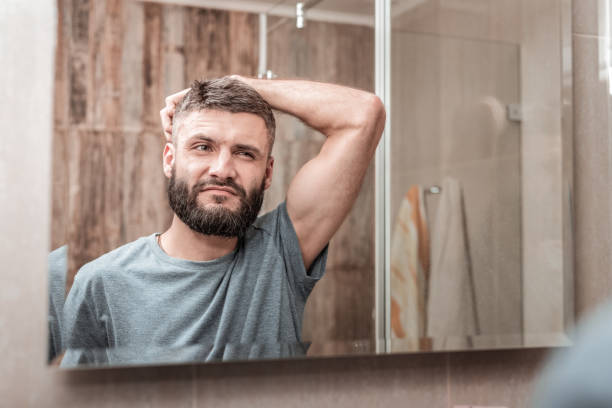 istock Bearded dark-haired mature man looking into mirror 1098010520