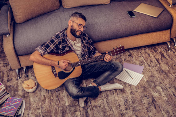 istock Delighted artistic bearded man playing the guitar 1098011966