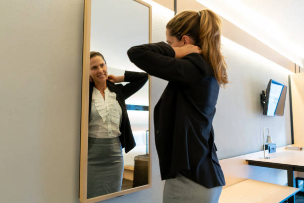 istock Business woman at her hotel room getting ready while looking at the mirror smiling 1098012548