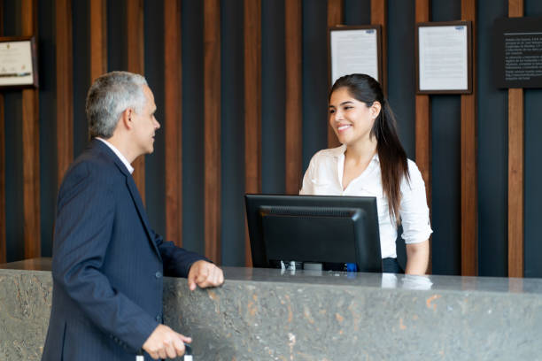 istock Friendly latin american hotel receptionist doing check in for male guest 1098012610