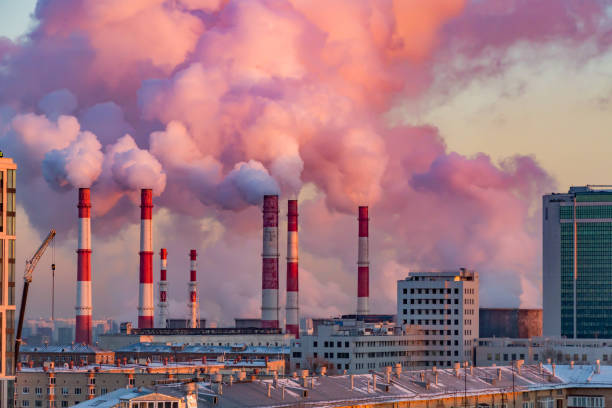 Steam or smoke comes from the pipes. Combined heat and power plant in the city. Landscape at sunset or dawn Steam or smoke comes from the pipes. Combined heat and power plant in the city. Landscape at sunset or dawn. smoke stack stock pictures, royalty-free photos & images