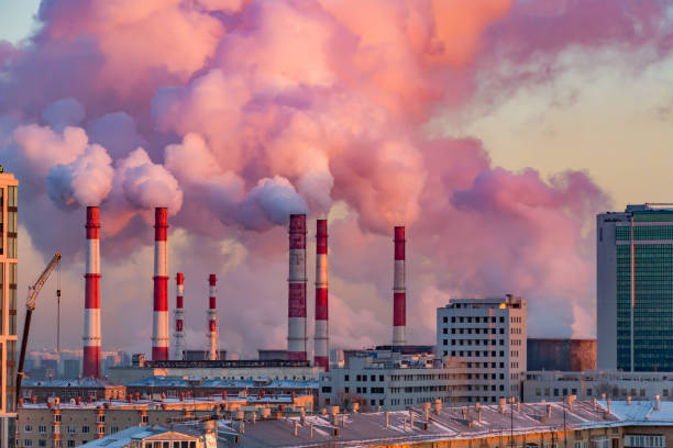 steam or smoke comes from the pipes. combined heat and power plant in the city. landscape at sunset or dawn - poluição do ar imagens e fotografias de stock