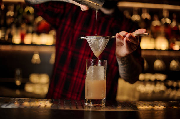 istock Barman pouring fresh orange drink into a glass 1098019586