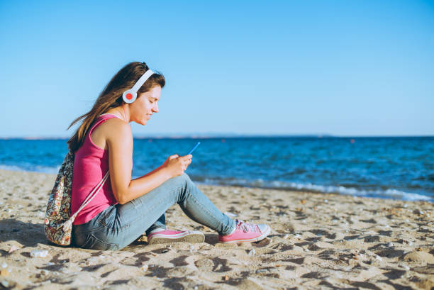 istock Woman using phone on the beach 1098023606