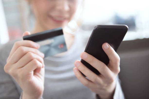 femme à l’aide de téléphone mobile achat en ligne avec carte de crédit - internet e commerce credit card retail photos et images de collection